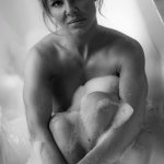 A naked woman sitting in a bath tub photo