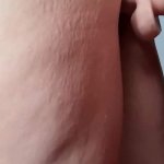 Tattoo slut with stretch marks on her ass pulls her thong to the side to fuck dildo against the wall